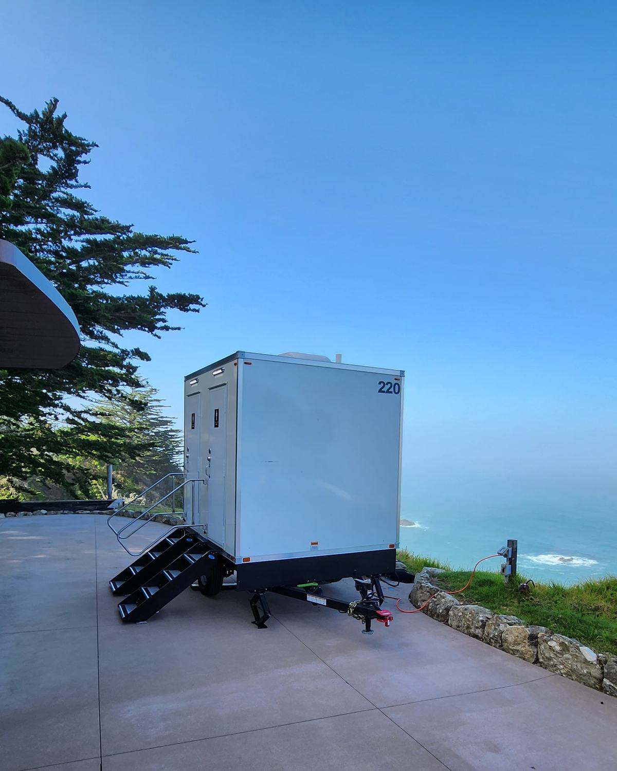2-stall luxury restroom trailer on a clifftop terrace above the Pacific at a Big Sur wedding, The Lavatory NorCal