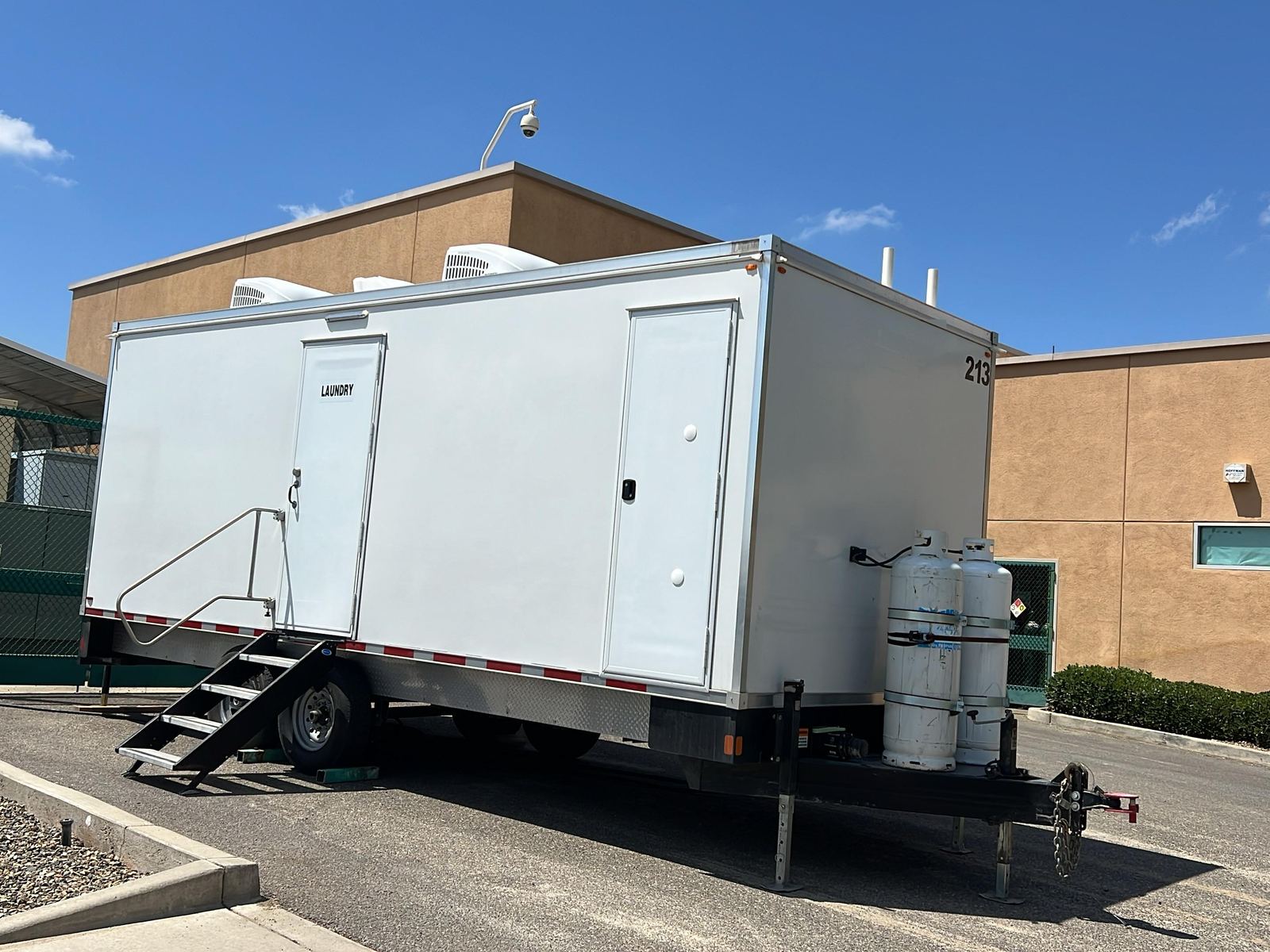 8-station laundry trailer with its laundry door, folding stairs and rooftop air conditioners, The Lavatory NorCal