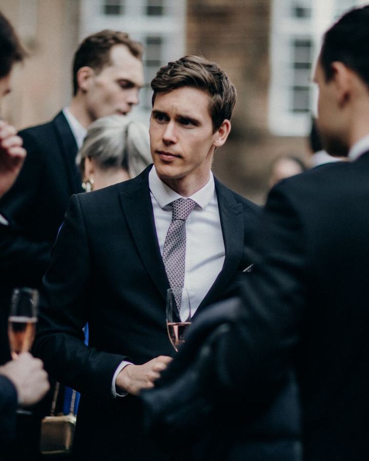 Guests in suits with champagne at a corporate reception, a use case for The Lavatory NorCal restroom trailers