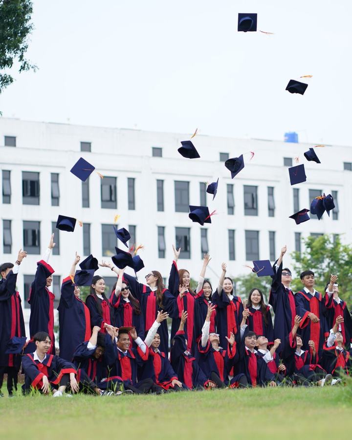Graduates throwing caps outside a campus building, a use case for The Lavatory NorCal restroom trailers