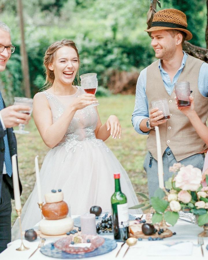 Wedding guests toasting with wine at an outdoor vineyard reception, a use case for The Lavatory NorCal luxury restroom trailers