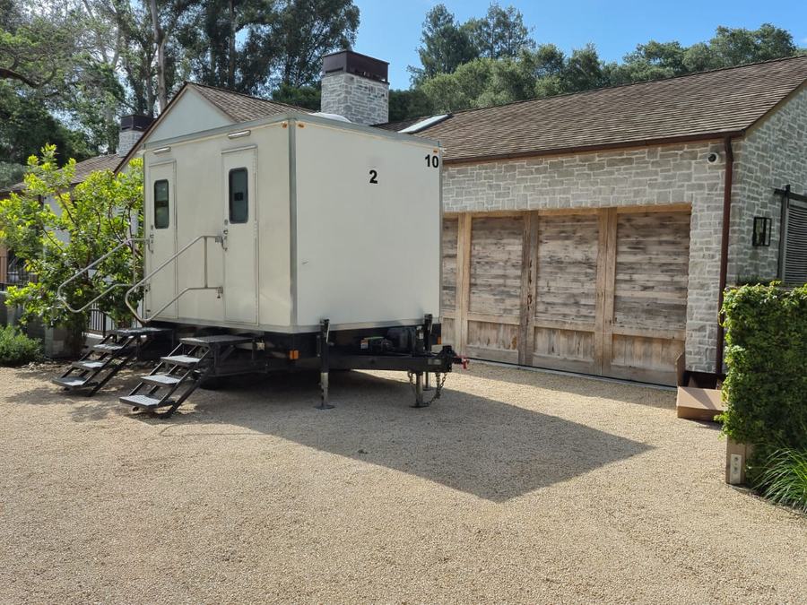 2-stall luxury restroom trailer on the gravel court of a stone estate for a wedding in Woodside, The Lavatory NorCal