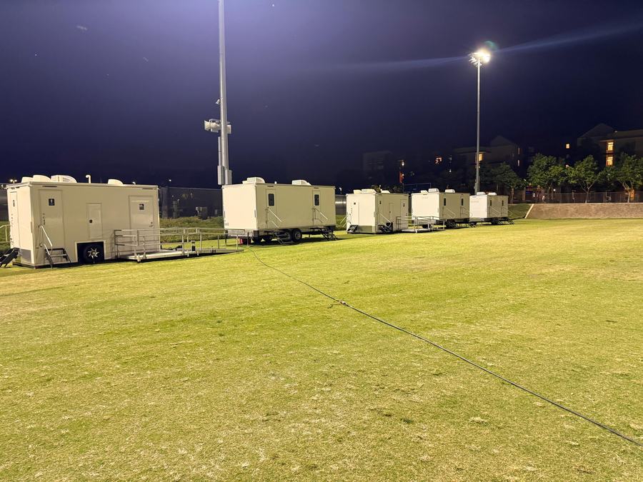 Row of 9-stall and ADA plus 2 restroom trailers under the field lights for a UC Merced campus event, The Lavatory NorCal