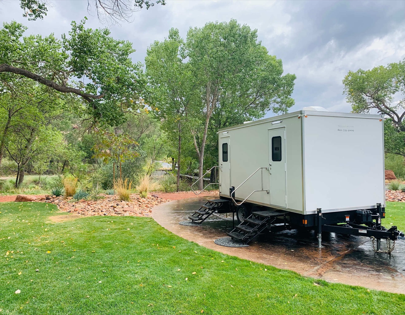 Restroom trailer leveled on a curved patio beside a green lawn for a backyard party, The Lavatory NorCal