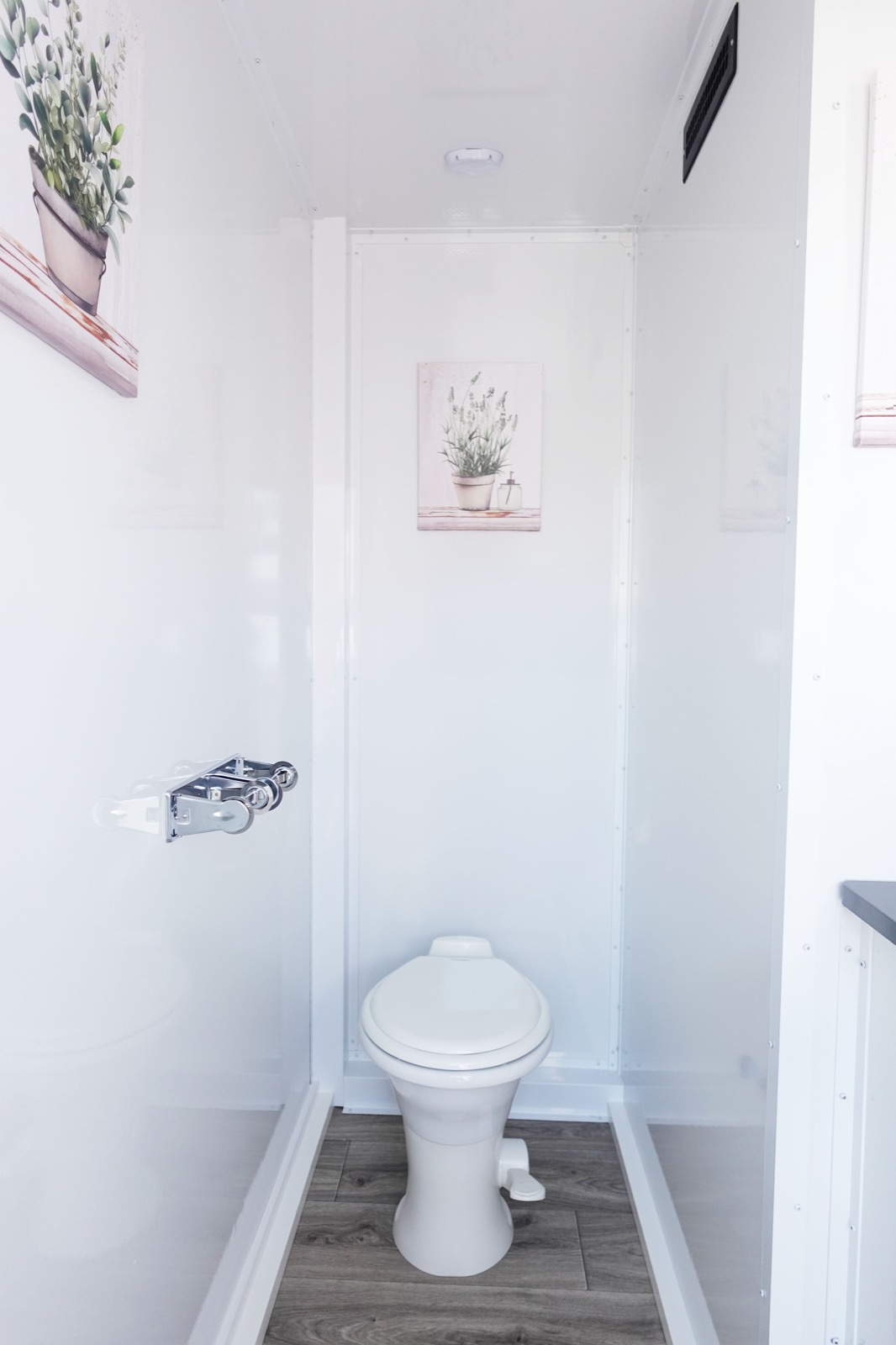 Private toilet stall with botanical art inside a 3-stall bathroom trailer, The Lavatory NorCal
