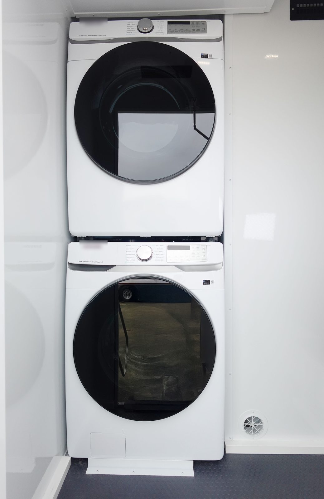 Stacked washer and dryer in the laundry room of the 4-stall shower, restroom and laundry combo trailer, The Lavatory NorCal