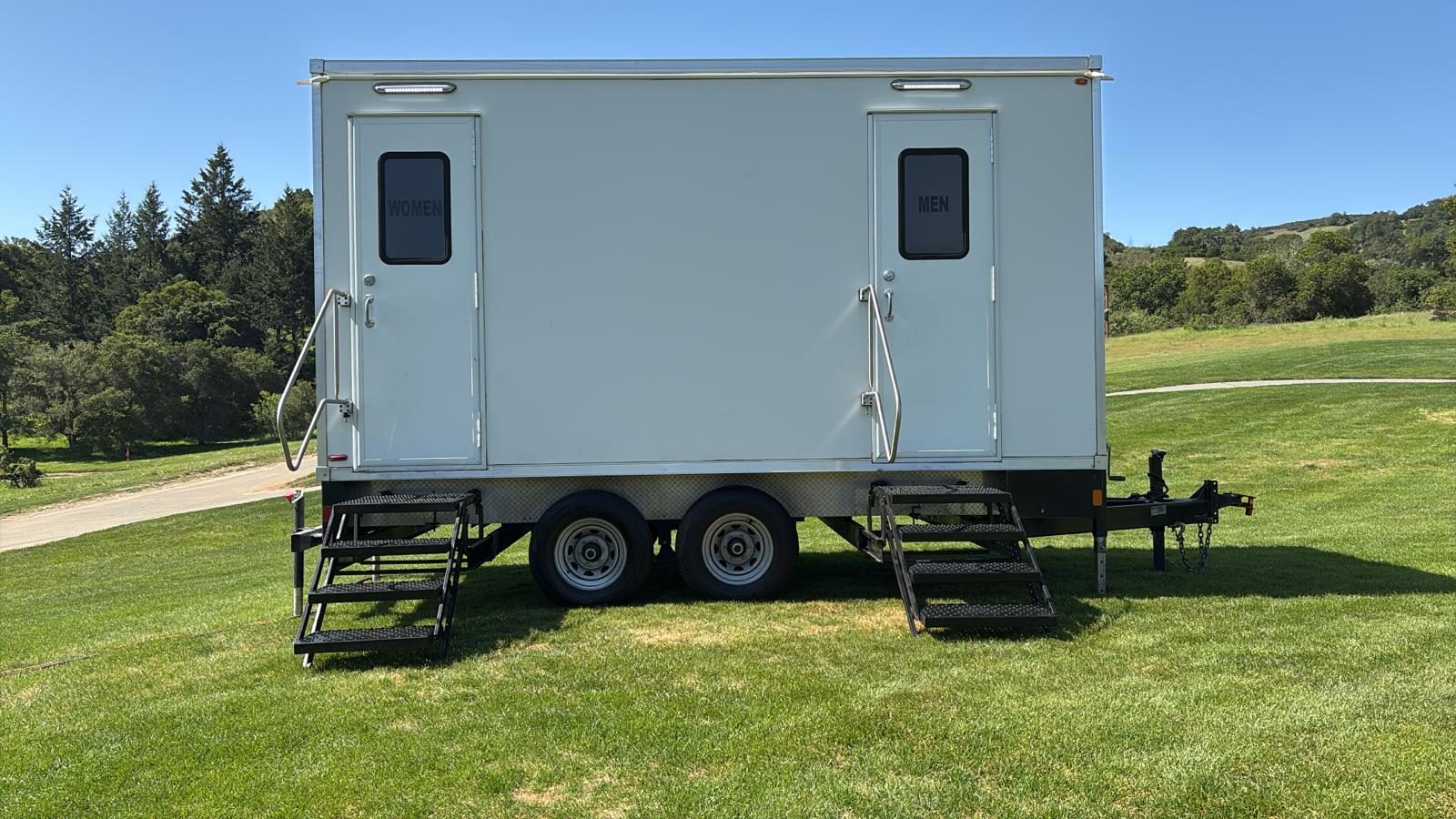 5-stall bathroom trailer with women's and men's doors on a grass lawn in Fairfax, Marin County, The Lavatory NorCal