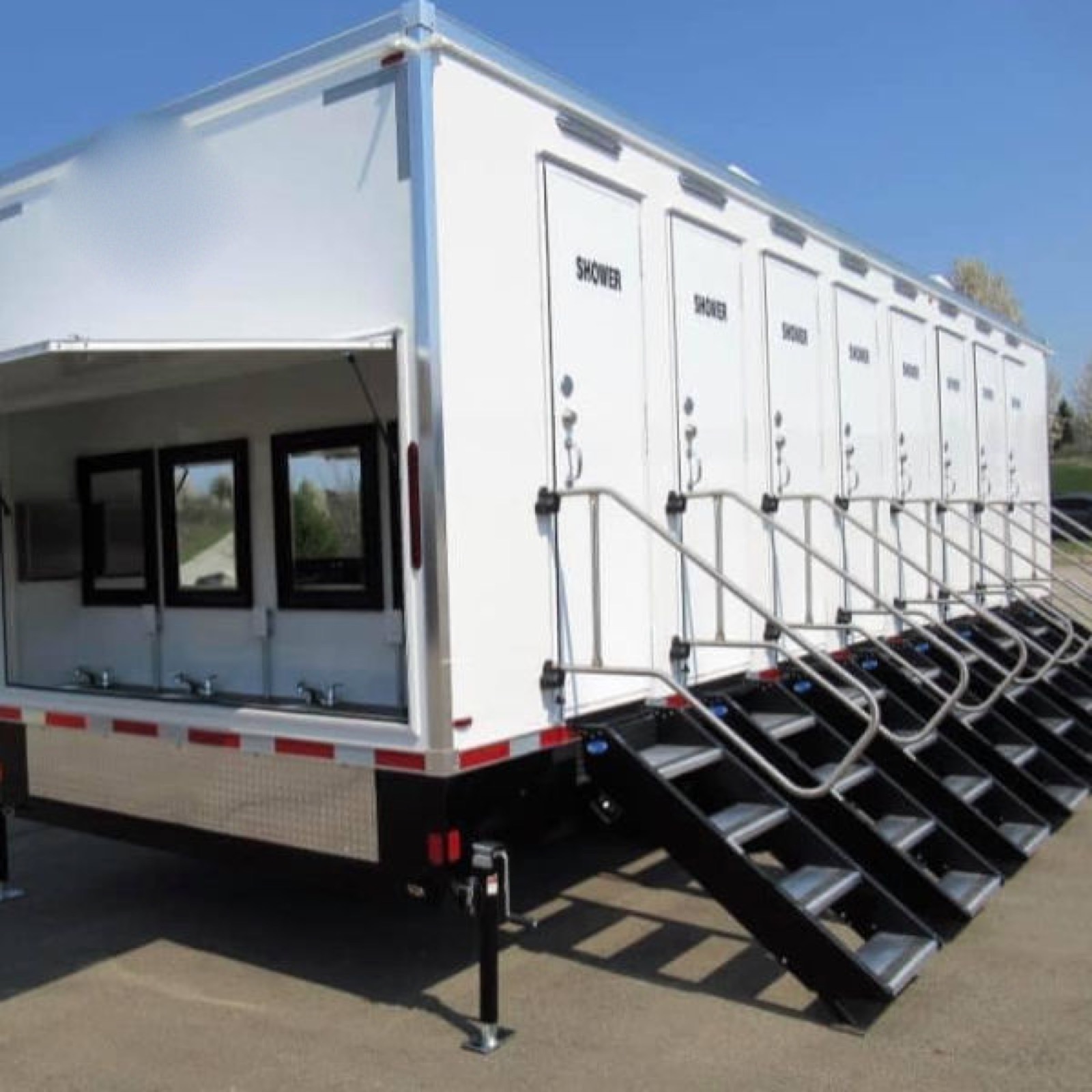 Open cover over the four outdoor sinks at the end of an 8-stall shower trailer, with railed stairs at every shower door, The Lavatory NorCal