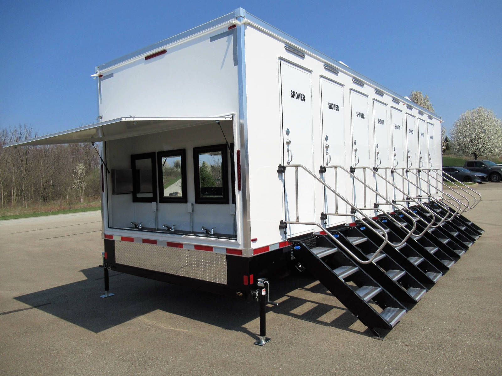 8-stall mobile shower trailer with a fold-up awning over its outdoor sink area, The Lavatory NorCal