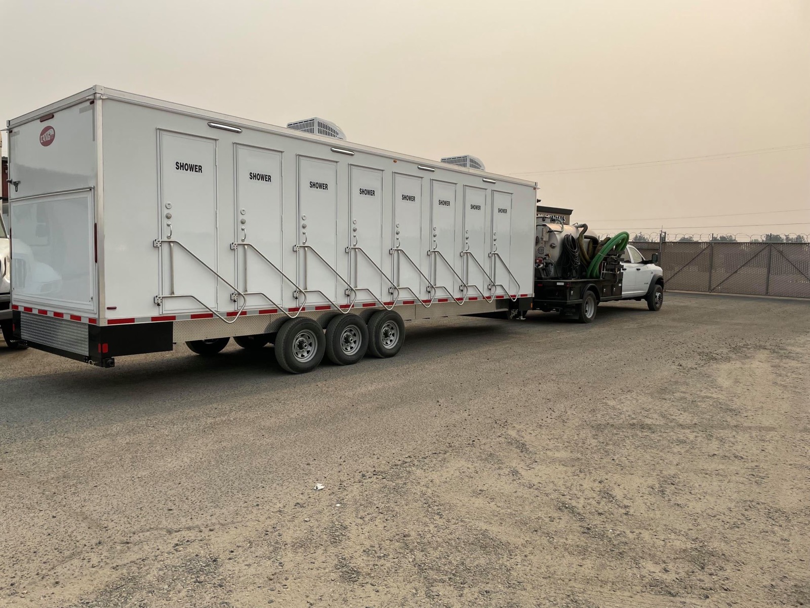 8-stall shower trailer hitched to our service truck under smoky skies on the way to an evacuation camp in Folsom, The Lavatory NorCal