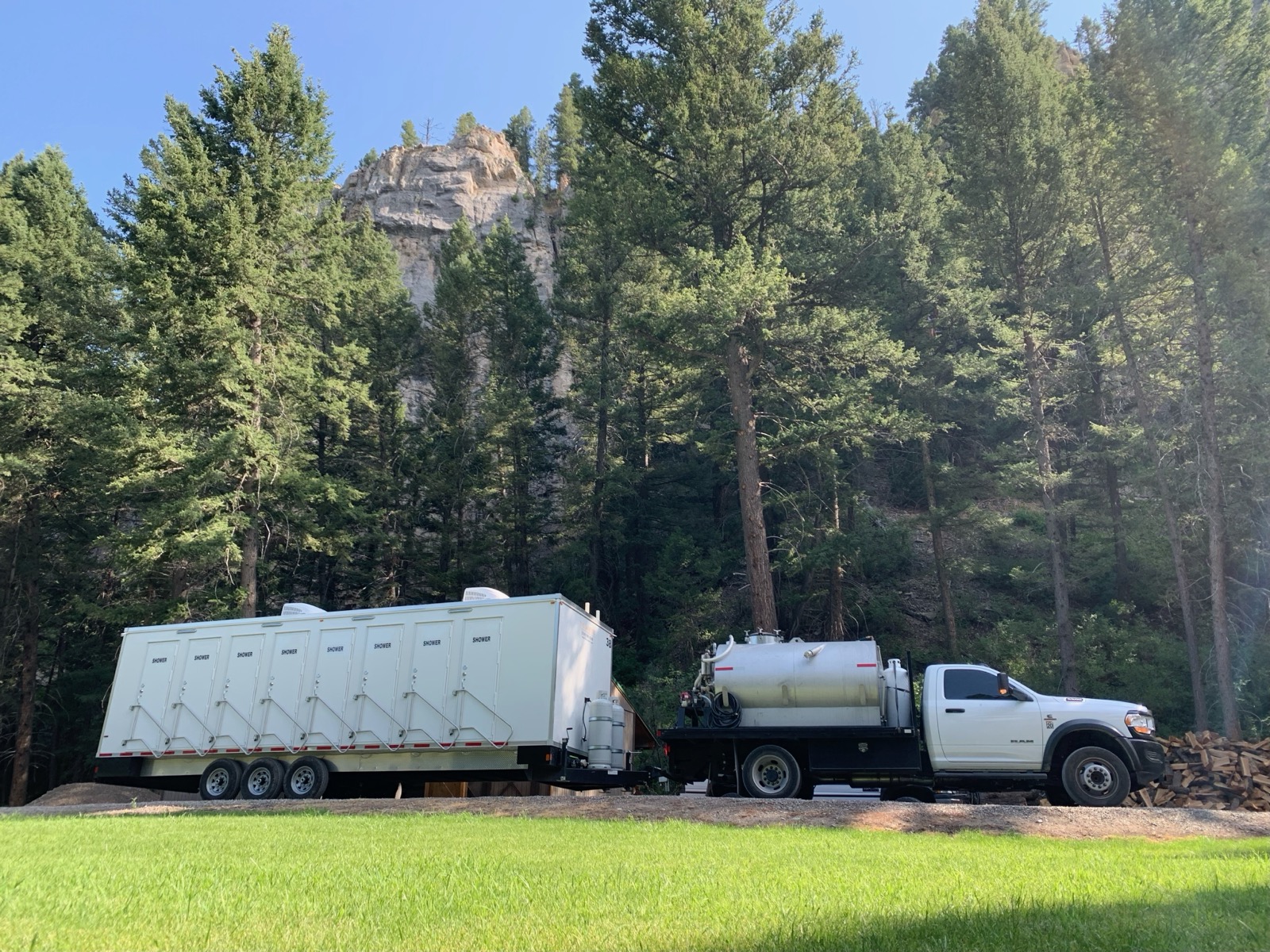 8-stall shower trailer towed by our service truck below pine-covered cliffs on the way to a mountain camp, The Lavatory NorCal