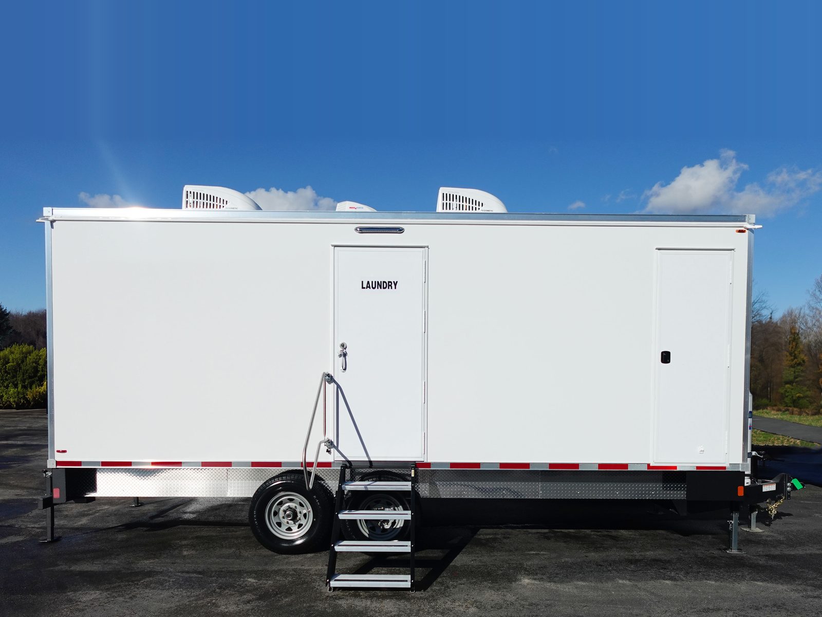 8-station laundry trailer side view with the laundry entry door, folding steps and two roof AC units, The Lavatory NorCal