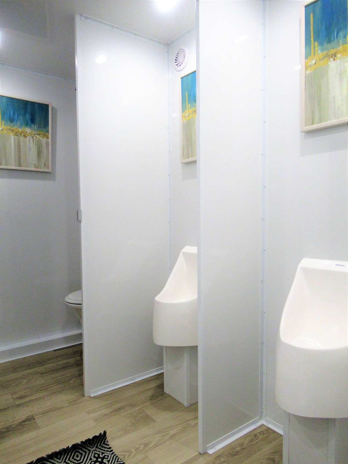 Urinals with privacy partitions on the men's side of a 9-stall bathroom trailer, The Lavatory NorCal