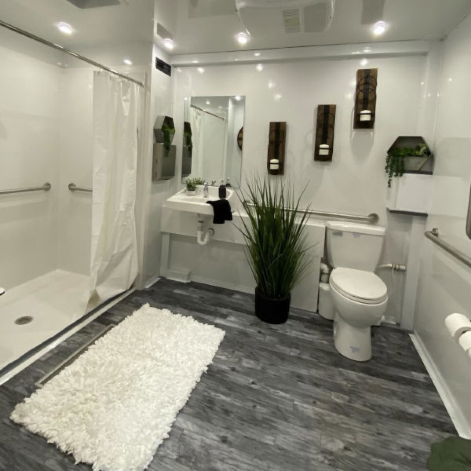 Wide view inside an accessible combo trailer with a roll-in shower, toilet and sink, The Lavatory NorCal