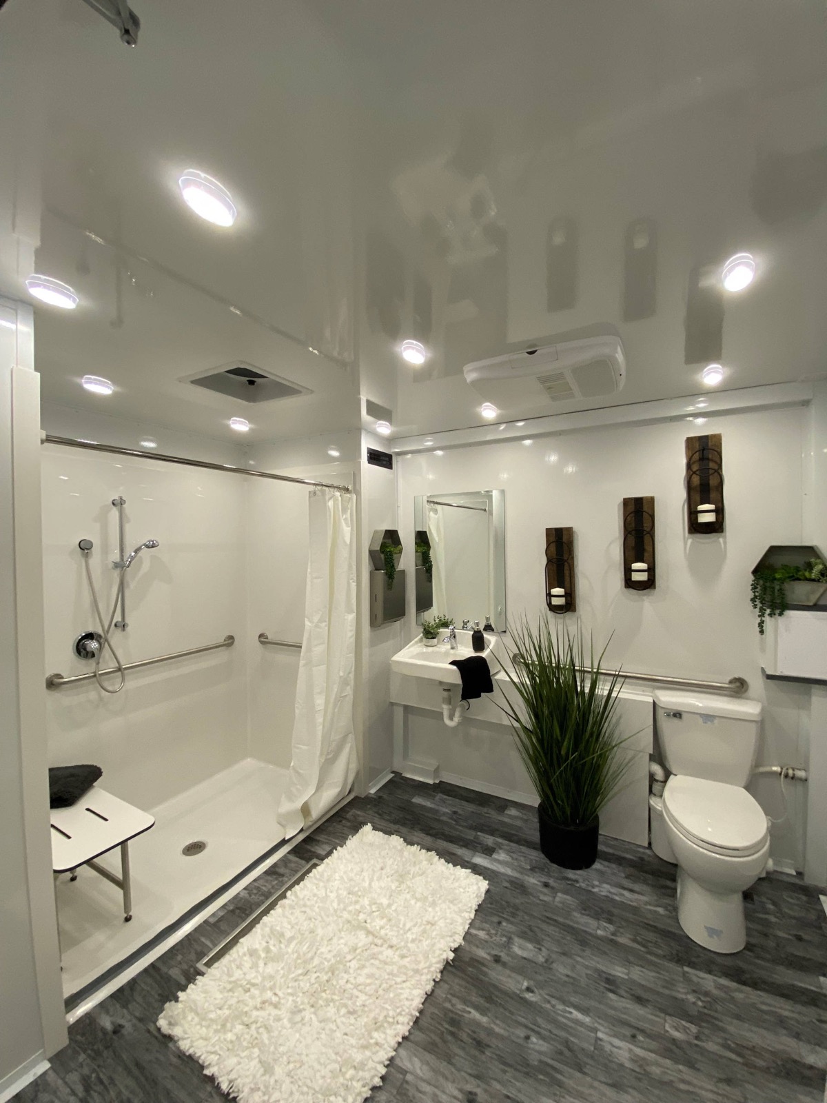 Accessible trailer room with a roll-in shower, fold-down seat, grab bars, toilet and sink, The Lavatory NorCal