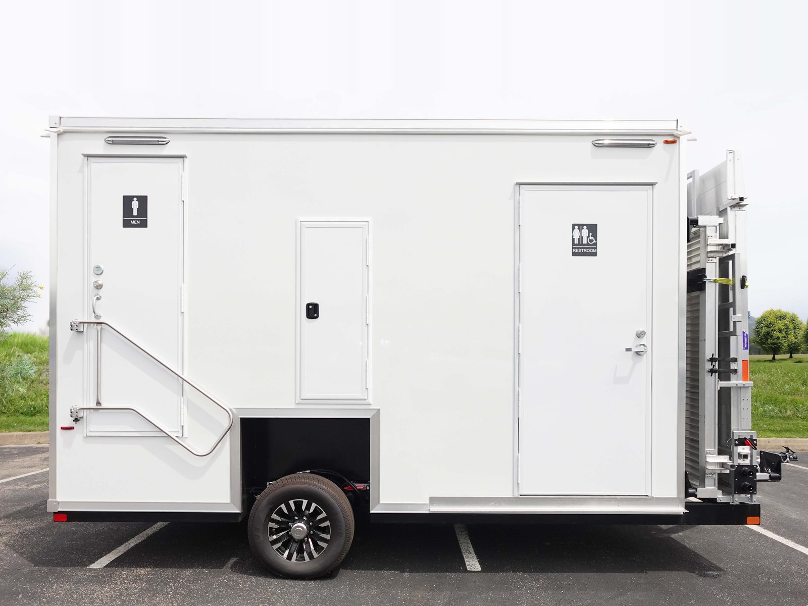ADA plus 2 bathroom trailer side view with the men's door and the accessible restroom door, ramp folded at the rear, The Lavatory NorCal