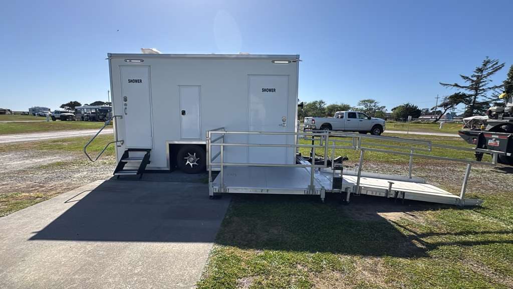 ADA plus 2 shower trailer with a platform and long aluminum ramp at a coastal fairground, The Lavatory NorCal