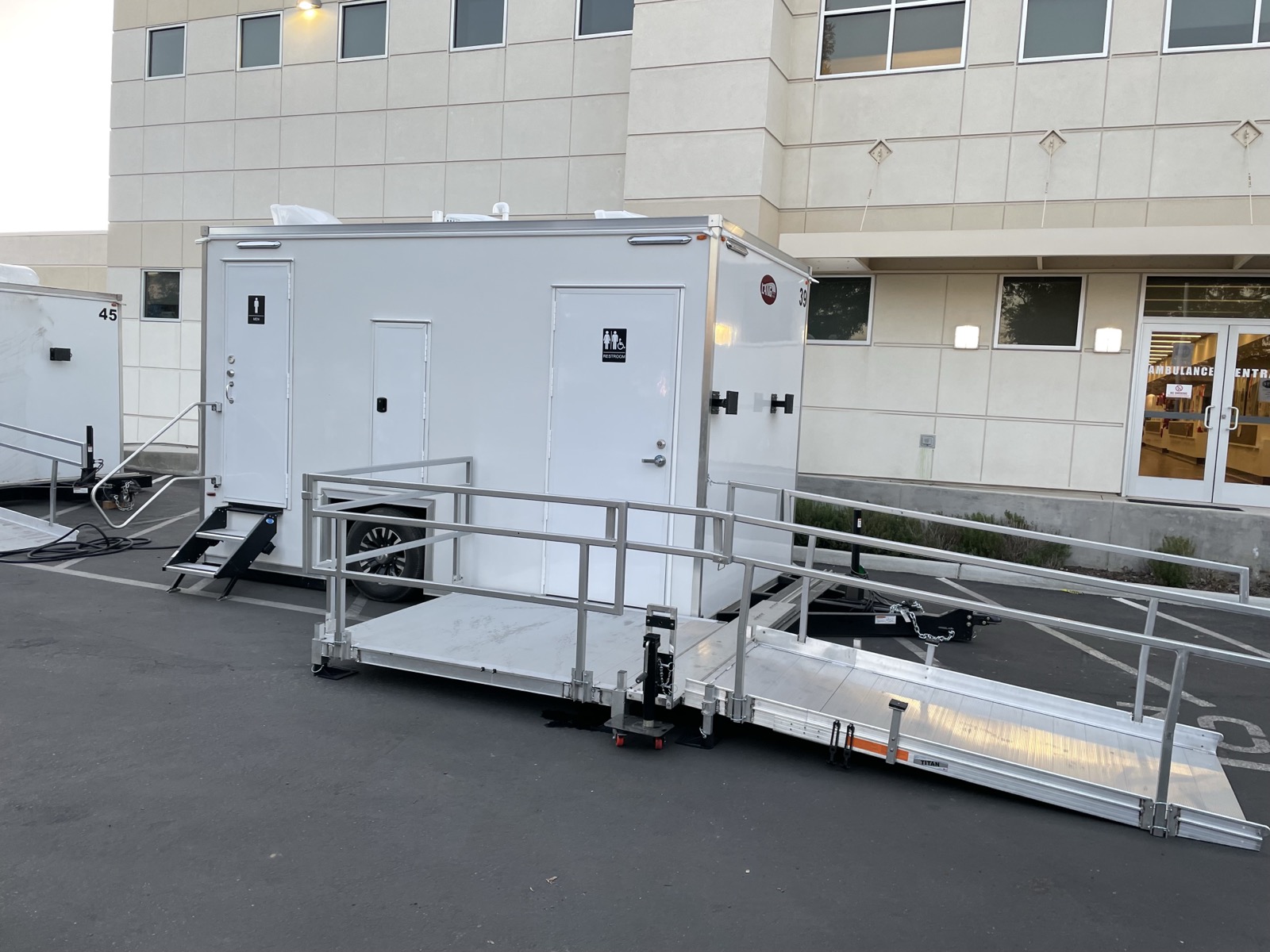 ADA plus 2 shower trailer with its ramp set up outside a medical building, The Lavatory NorCal