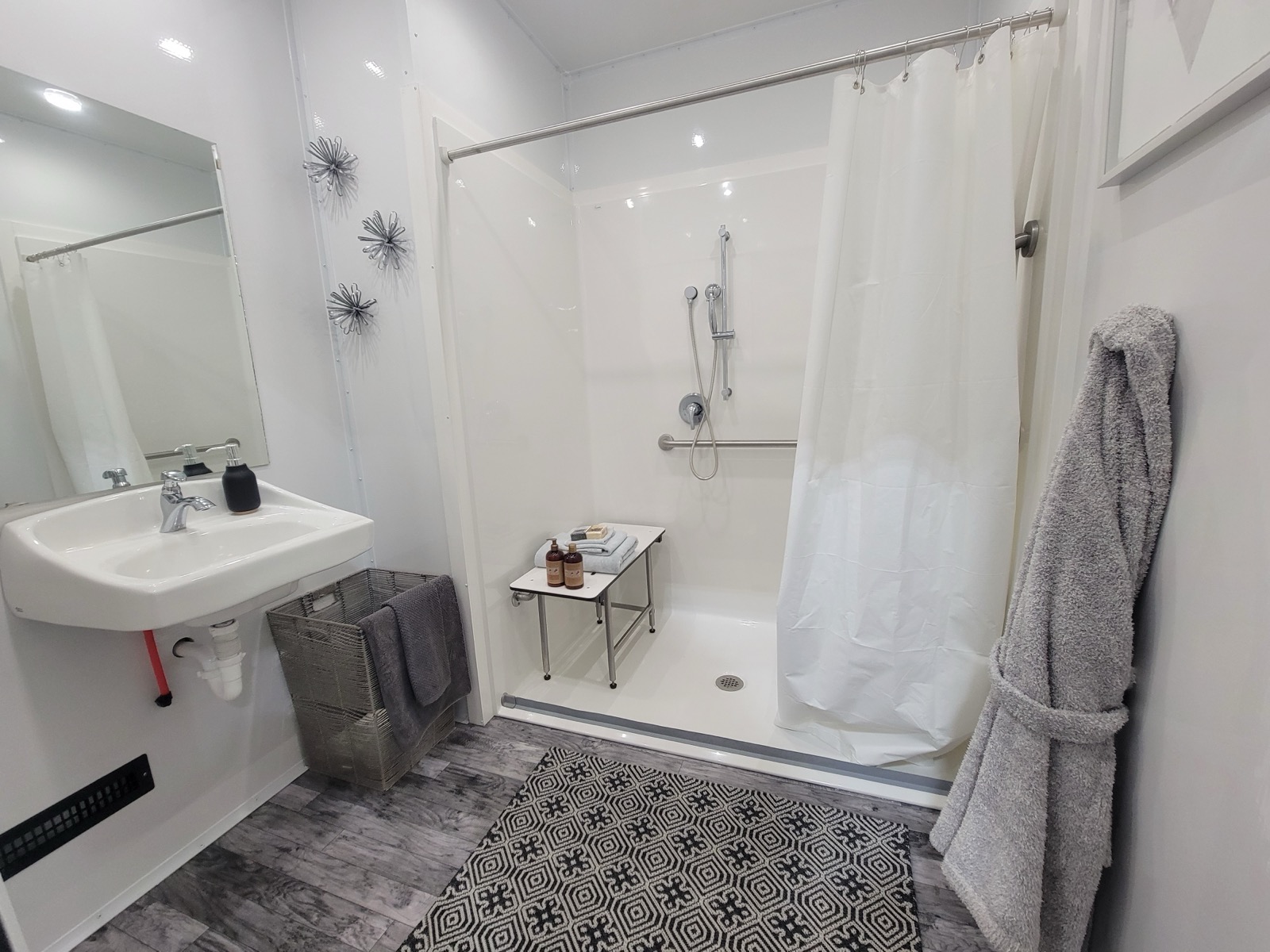 Roll-in accessible shower with a bench seat, handheld wand, grab bar, wall-hung sink and robe, The Lavatory NorCal