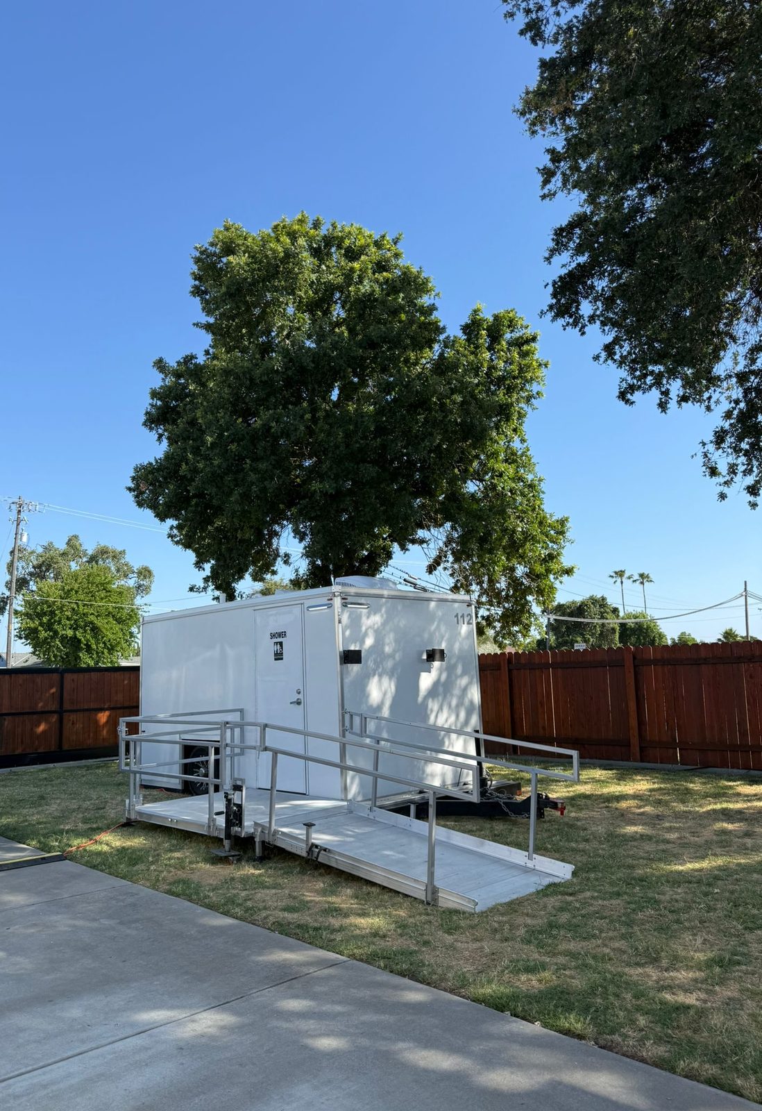 ADA shower and restroom combo with a railed aluminum ramp on a lawn in Sacramento, The Lavatory NorCal