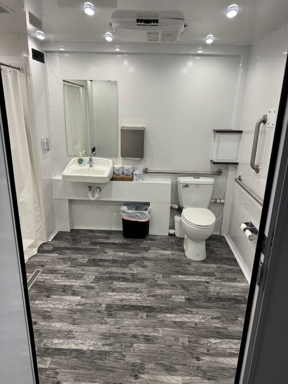 Inside an ADA shower and restroom combo: roll-in shower, wall sink, toilet and grab bars, The Lavatory NorCal