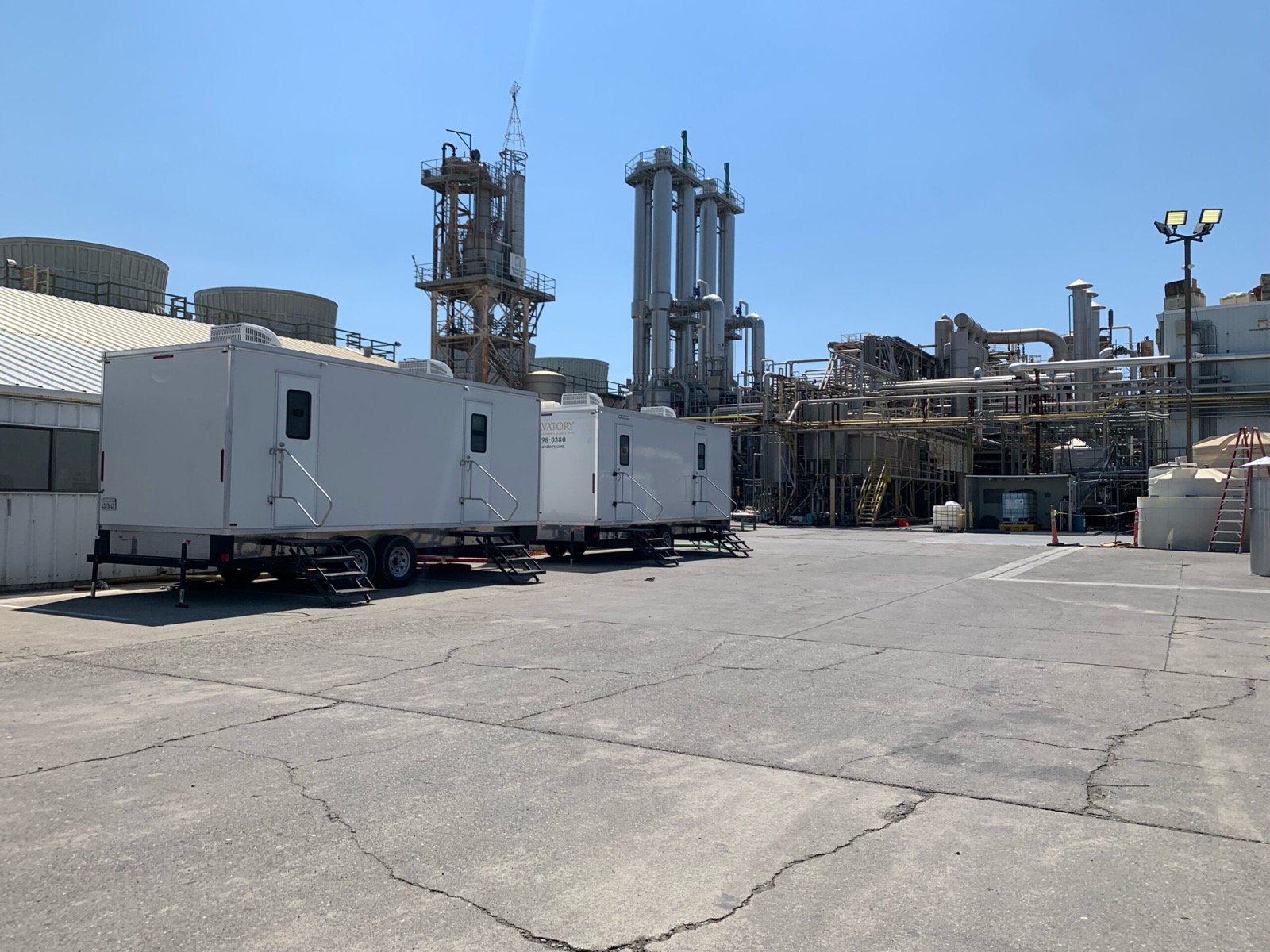 Two restroom trailers parked in an industrial plant yard for workers on long shifts, The Lavatory NorCal