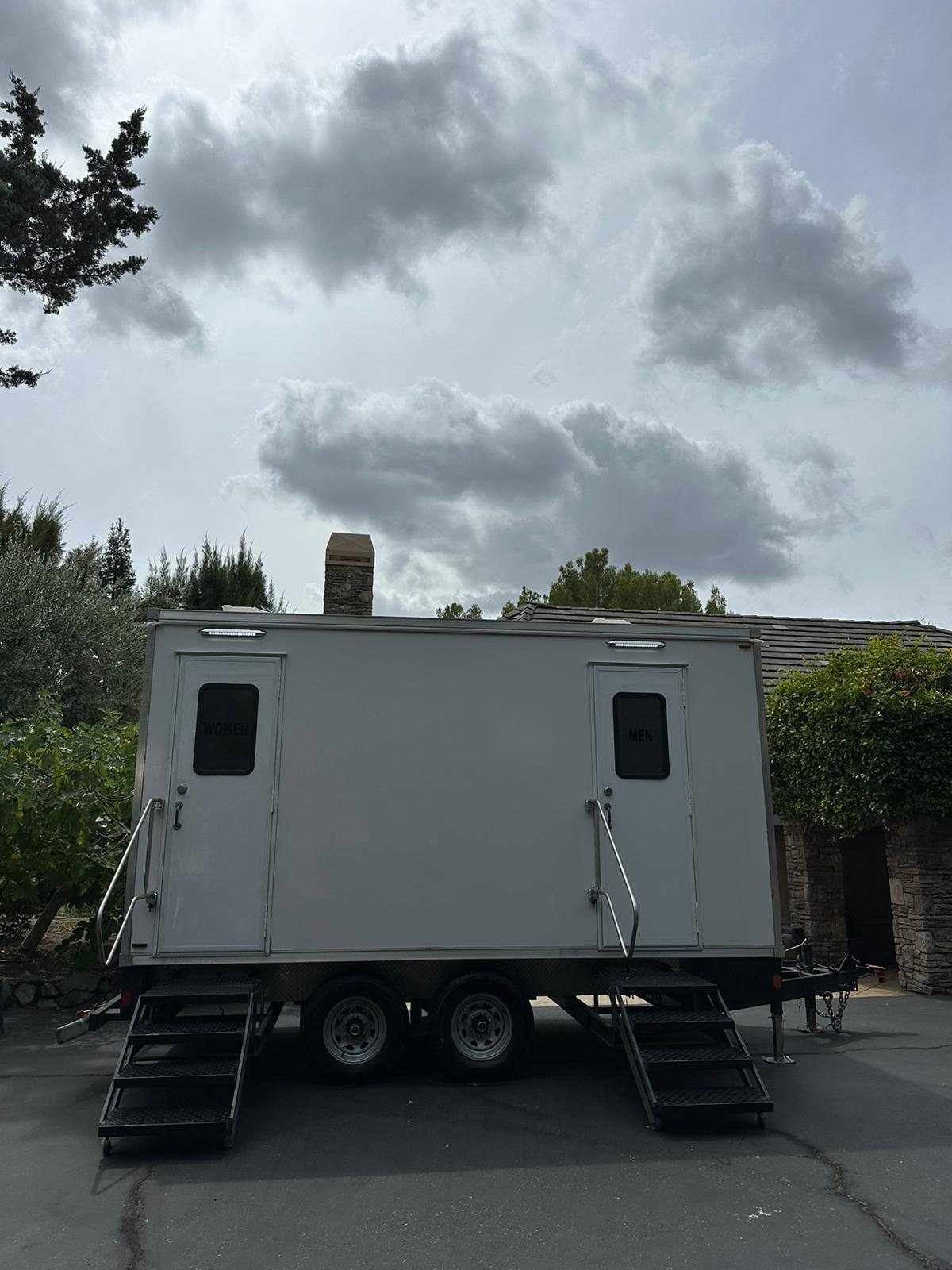 2-stall bathroom trailer parked on a home driveway in Walnut Creek under a cloudy sky, The Lavatory NorCal