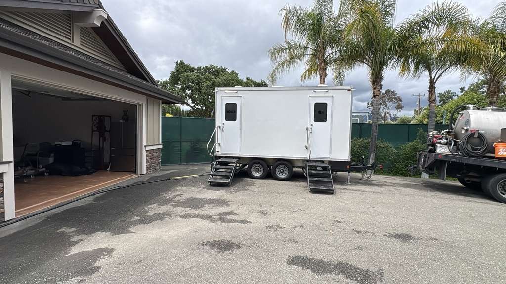 Two-door bathroom trailer and our service truck on a private driveway in Pleasanton, east of Fremont, The Lavatory NorCal