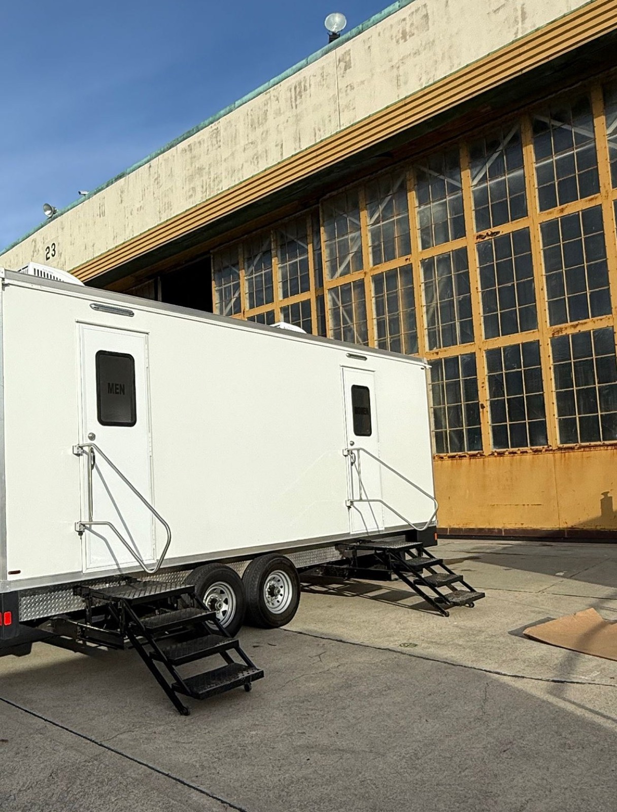 9-stall bathroom trailer with men's and women's stairs parked beside a historic hangar at Alameda Point near Oakland, The Lavatory NorCal