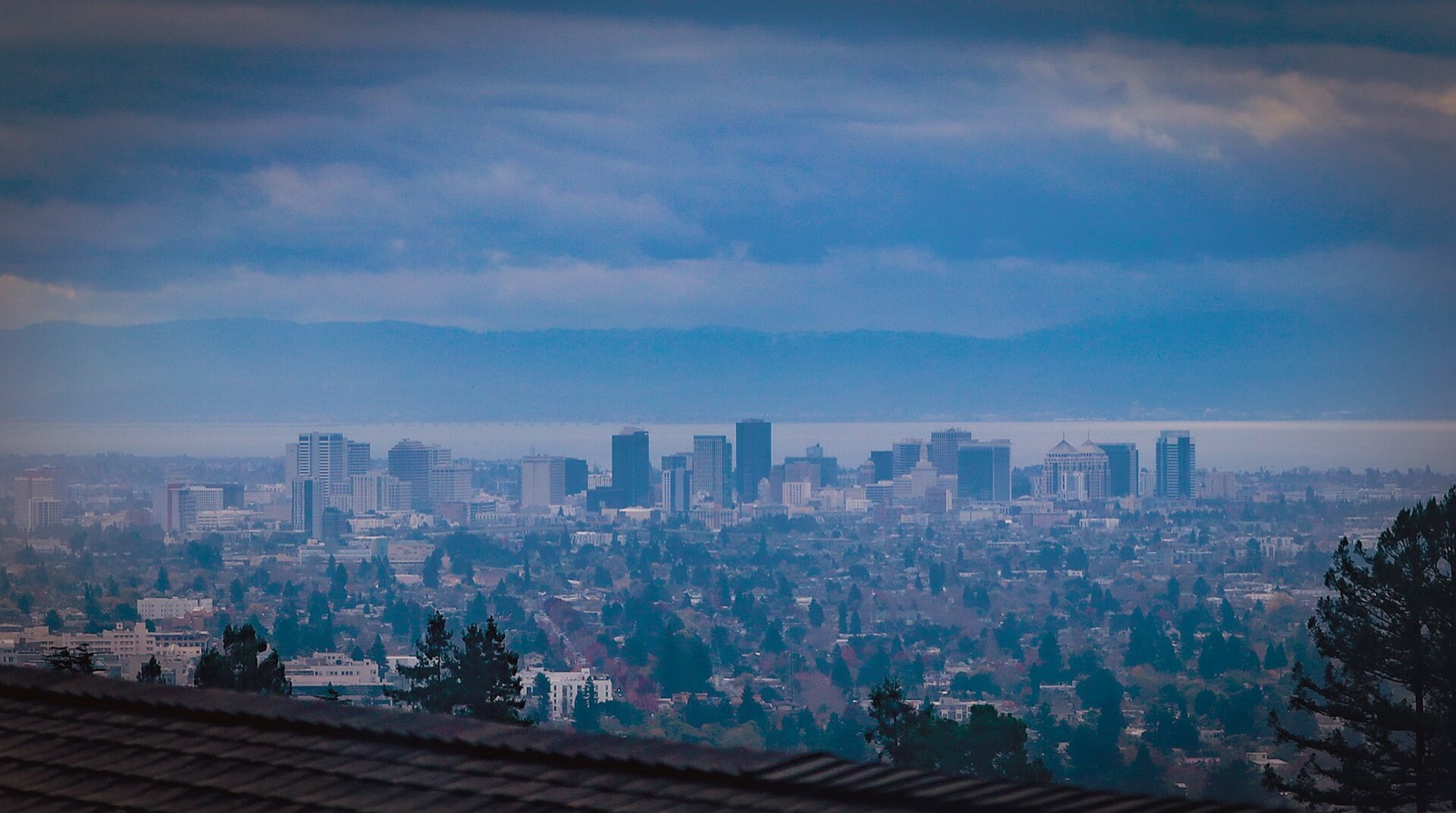Downtown Oakland skyline under storm clouds seen from the East Bay hills, an area served by The Lavatory NorCal