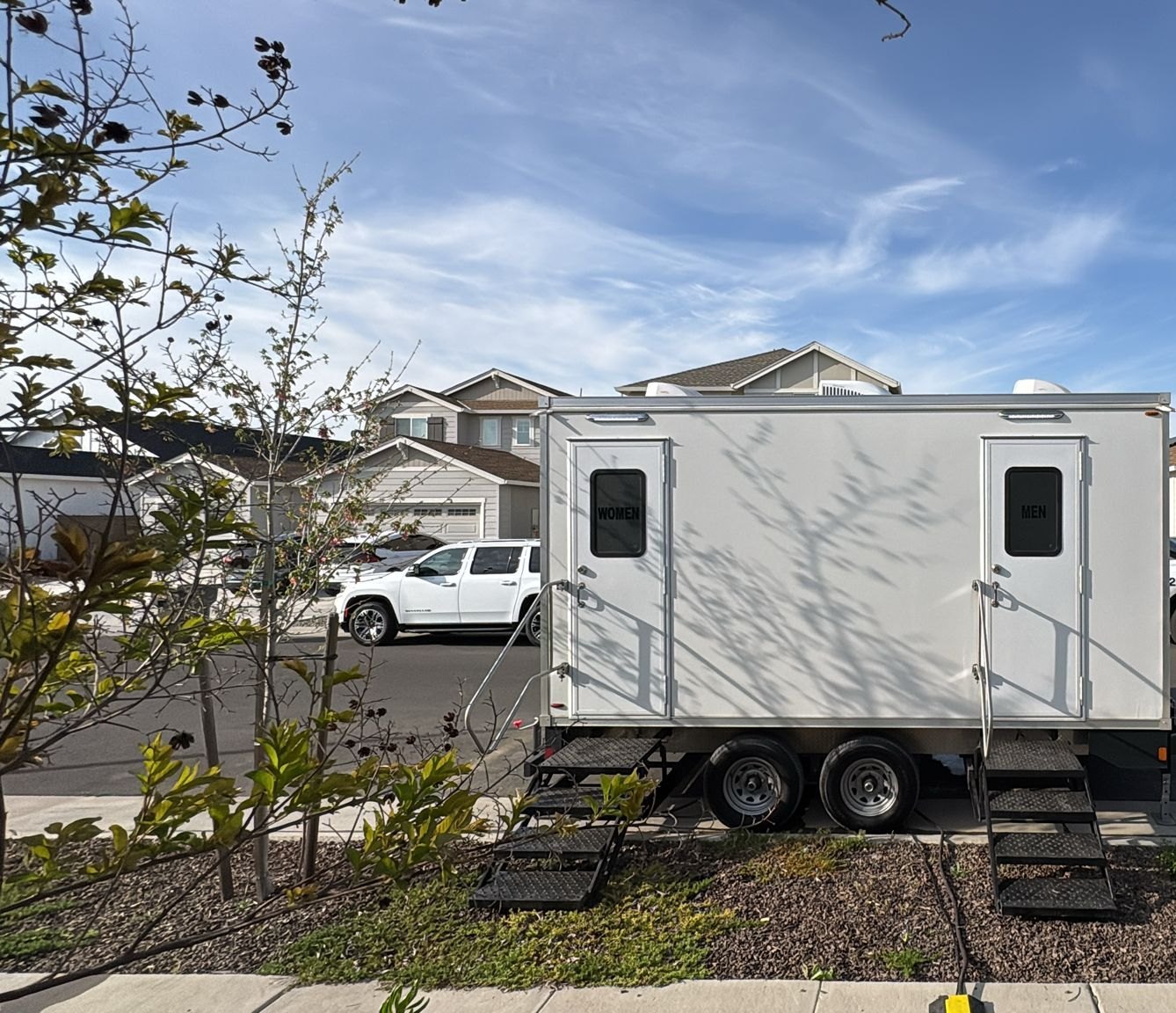 2-stall portable bathroom trailer with steel steps parked along a new street on the west side of Roseville, The Lavatory NorCal