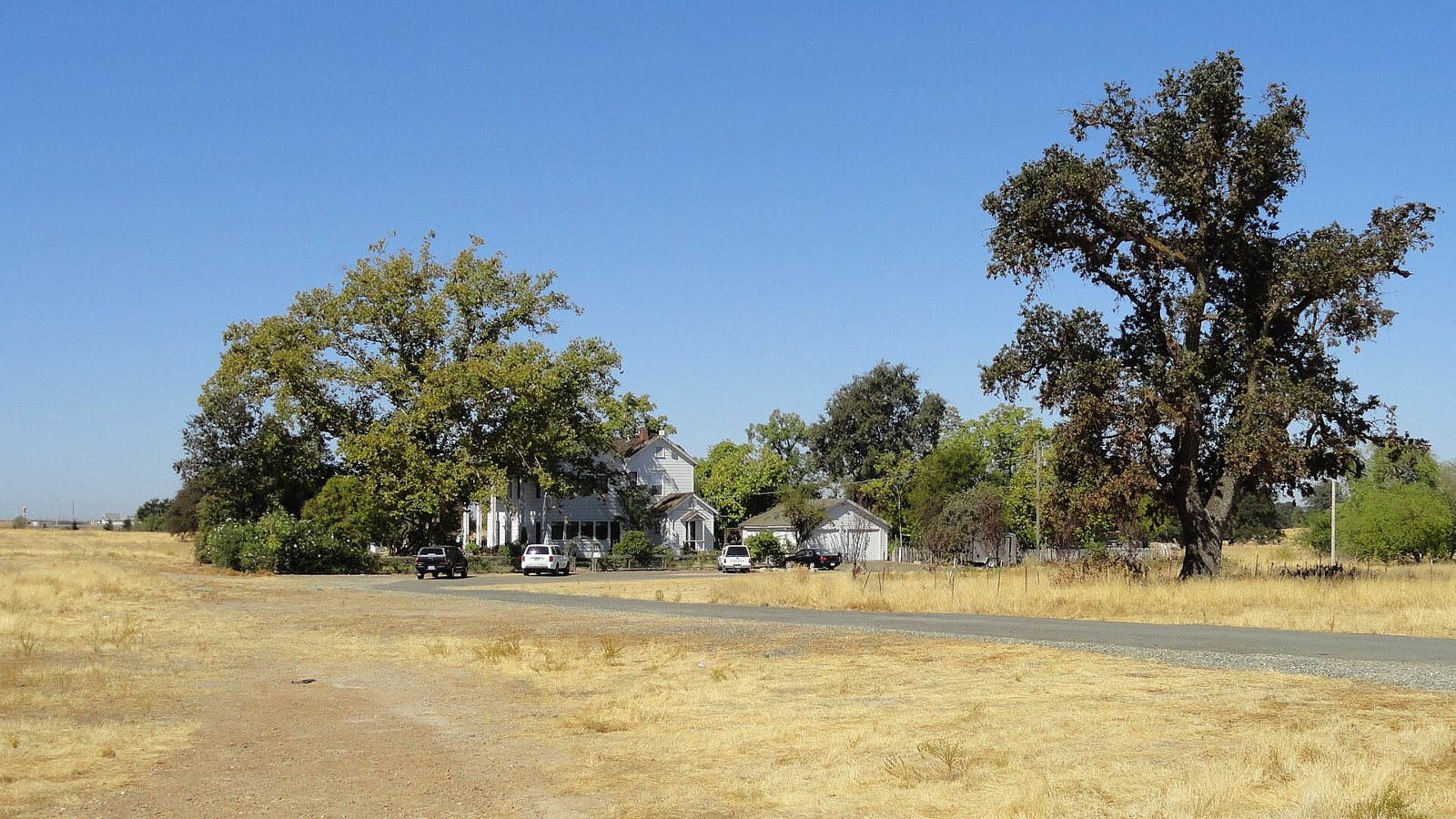 Historic Fiddyment Ranch farmhouse under valley oaks on open grassland in west Roseville, near where The Lavatory NorCal delivers