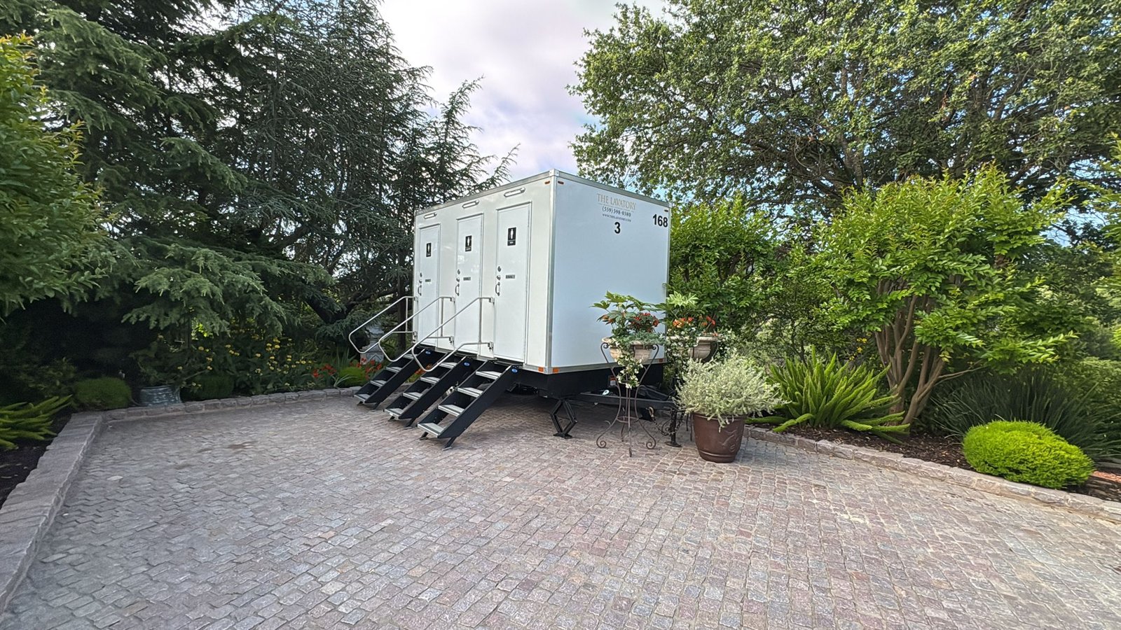 3-stall restroom trailer on a cobblestone drive in a West Valley estate garden near San Jose, The Lavatory NorCal
