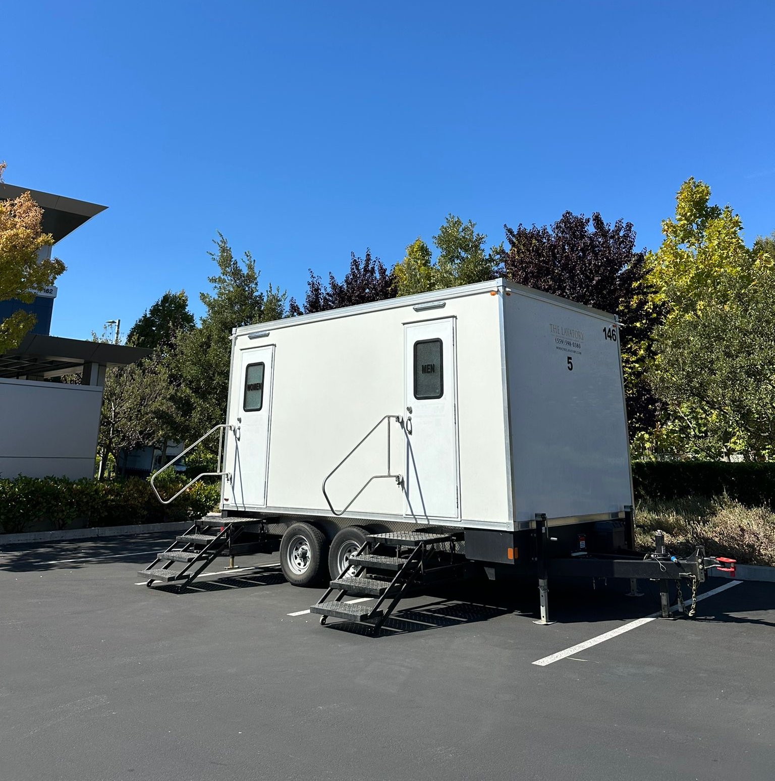 2-stall portable bathroom trailer with steel stairs in an office campus parking lot near Sunnyvale, The Lavatory NorCal
